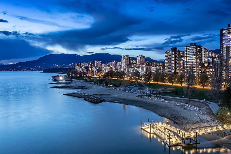 A twilight view of False Creek, Vancouver (still water on a low shoreline, with skyscrapers jutting up like the teeth of a key)