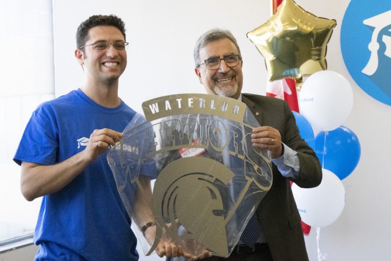 Martin Basiri and University of Waterloo President Feridun Hamdullahpur holding Waterloo Warriors sign