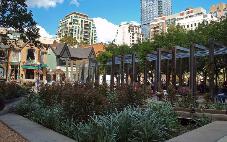 A photo of Village of Yorkdale Park, Toronto, featuring the plants and greenery there as well as some homes in the neighbourhood.