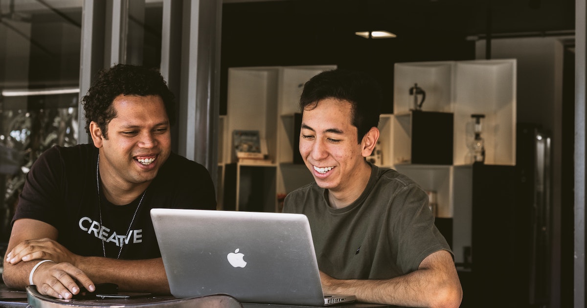 Two men working at laptop
