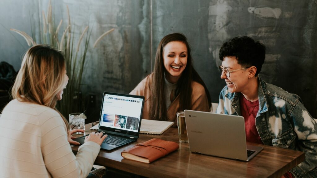 Three colleagues laughing at table