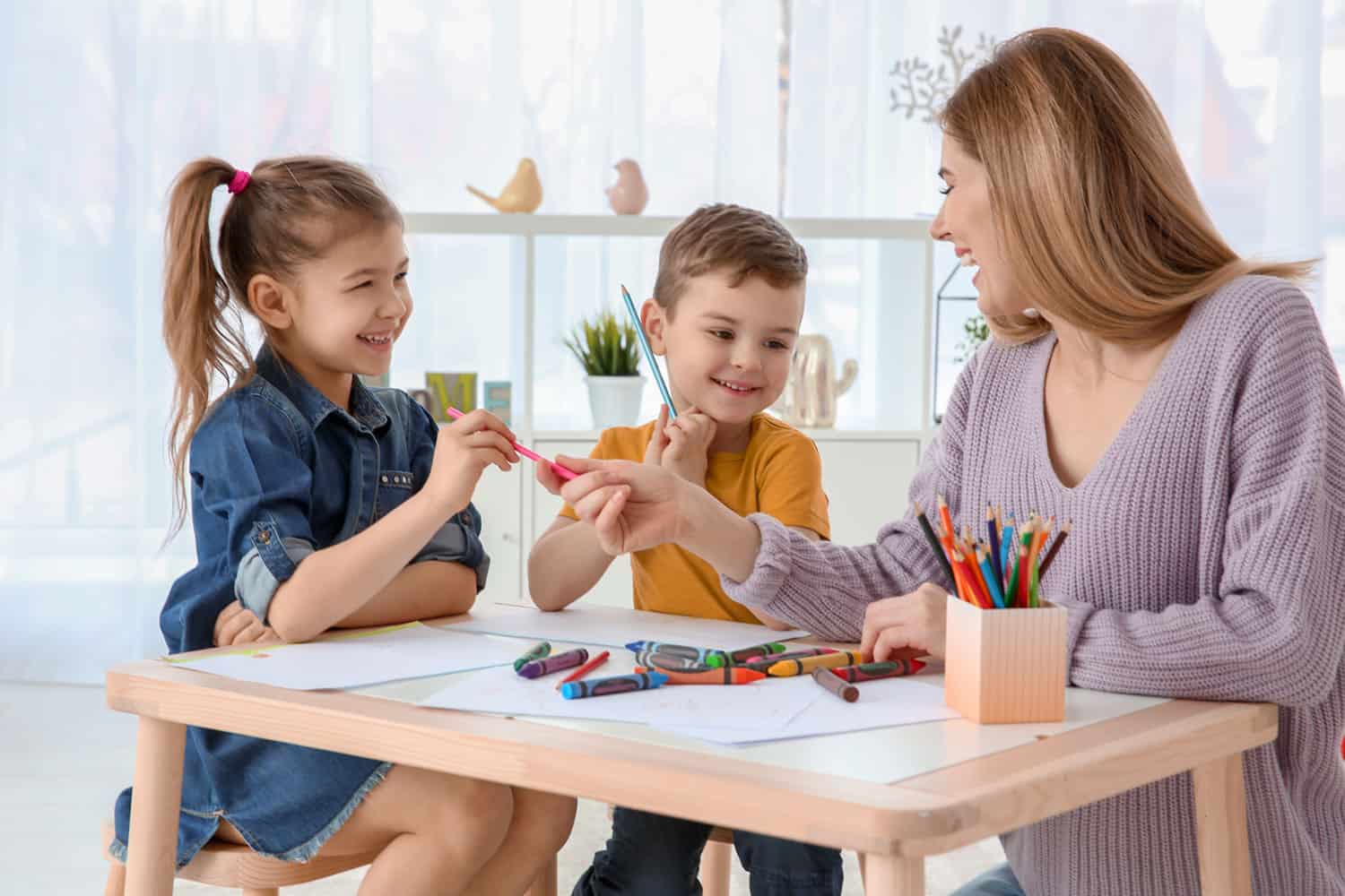 A photo of a babysitter with two kids.