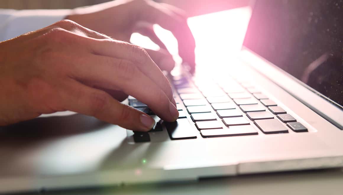 Photo of a person working on their laptop.