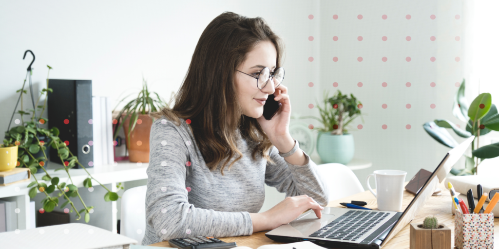 A photo of a woman sitting at her desk working on her laptop.