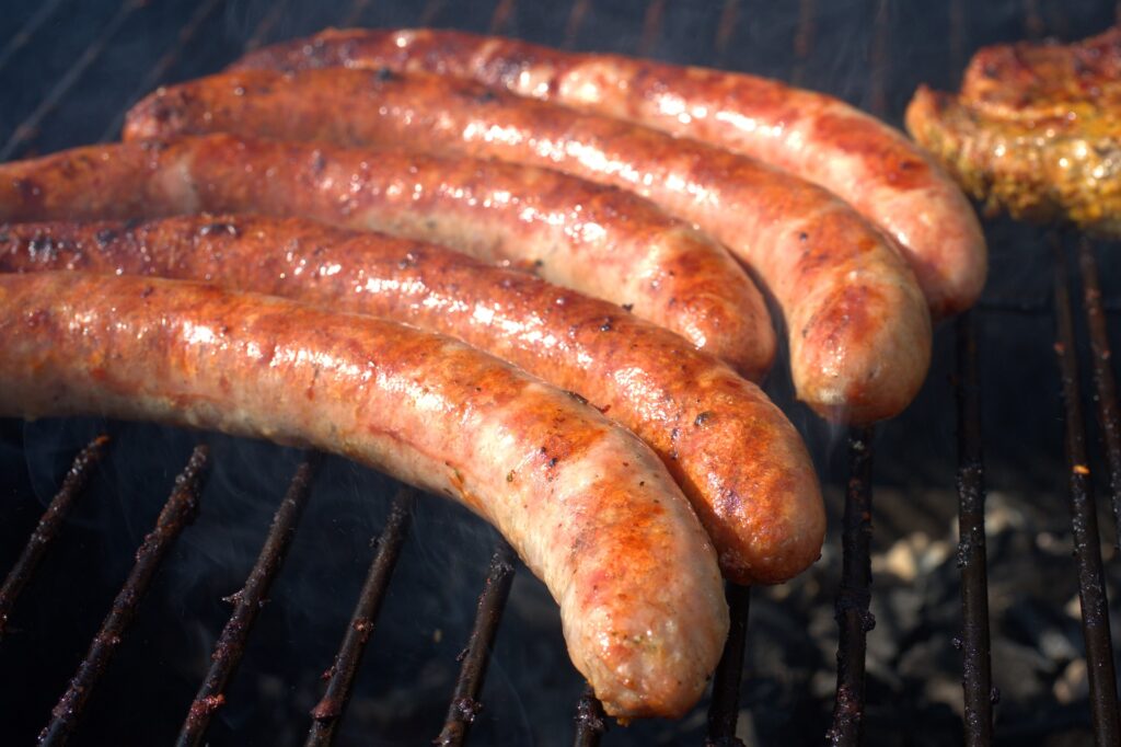 Australian food - Five grilled sausages sit on a barbecue.