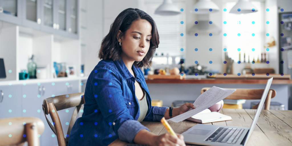 A photo of a woman sitting at her desk working on her laptop.