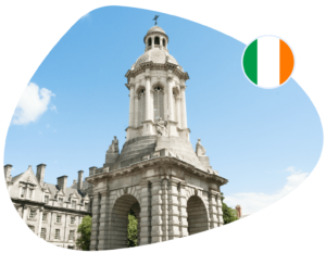 A white stone tower stands against a blue sky, with an Irish flag adjacent