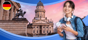 A young woman wearing headphones and a backpack, and carrying a phone and a disposable coffee cup is framed by the German flag and two impressive stone buildings with ornate sculptures at twilight.