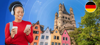 A smiling young woman looks down at her phone while holding a white to-go coffee mug. She is framed by a photographic background with colourful multistorey houses, a warm-hued stone castle, and a German flag logo.